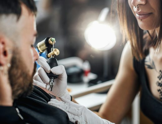 Professional Female Tattooist Working in a Tattoo Studio
