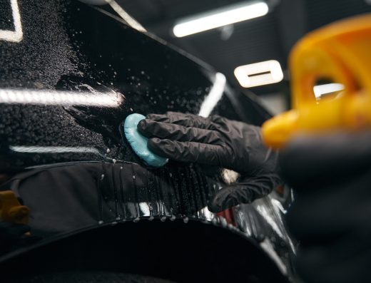 Auto detailing professional preparing automobile for polishing